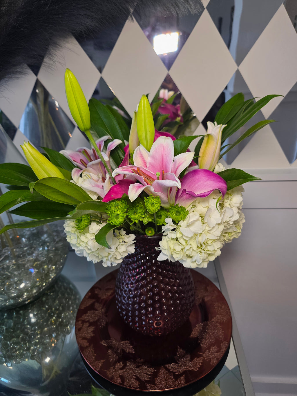 Bouquet of flowers with a decorative hat on a checkered floor